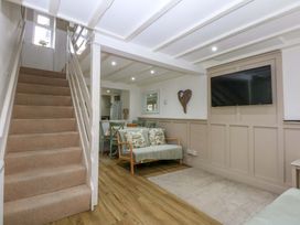 A living room with a staircase and seating area at 27 Kingshead Street Pwllheli