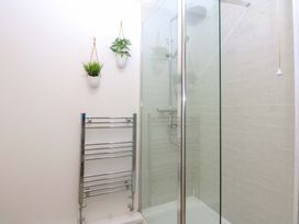A bathroom with a shower and towel radiator at 27 Kingshead Street Pwllheli