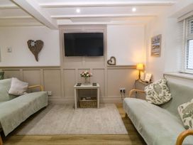 A living room with a television and a coffee table at 27 Kingshead Street Pwllheli