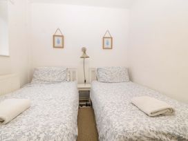 A bedroom with twin beds and a bedside lamp at 27 Kingshead Street Pwllheli