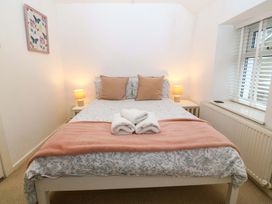A bedroom with a bed and bedside lamps at 27 Kingshead Street Pwllheli