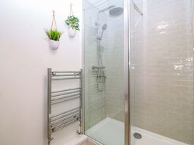 A bathroom with a glass shower and towel radiator at 27 Kingshead Street, Pwllheli