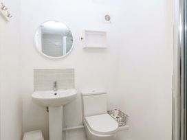 A bathroom with a sink, toilet, and mirror at 27 Kingshead Street Pwllheli
