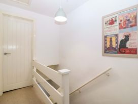 A staircase with a door and wall art at 27 Kingshead Street Pwllheli