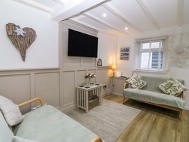 A living room with a television and sofas at 27 Kingshead Street Pwllheli