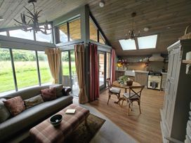 A living room with a sofa and dining area at The Hare's Shack in Garnett Bridge, Longsleddale. Near Kendal