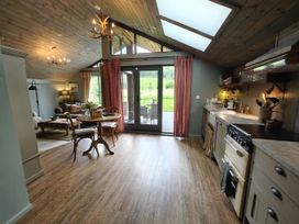 A kitchen with a dining area and open doors to the garden at The Hare's Shack, Garnett Bridge, Longsleddale. Near Kendal