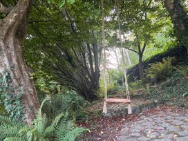 A swing hanging between trees in a garden at Afallon in Menai Bridge