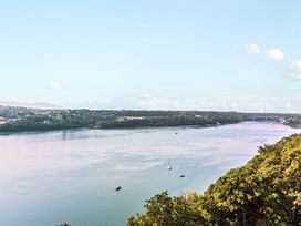 A landscape view of a river with boats and trees at Afallon in Menai Bridge