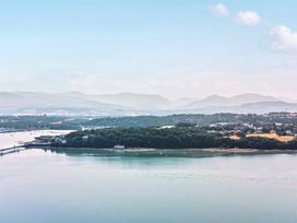 An aerial view of water, land, and mountains at Afallon in Menai Bridge