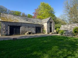 A building with a stone exterior and wooden features at Carrows Stable in Morwenstow