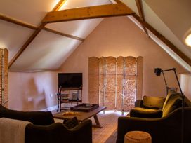 A living room with a television and sofa at Carrows Stable in Morwenstow