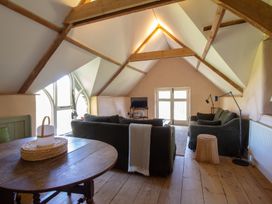 A living room with a sofa and table at Carrows Stable in Morwenstow
