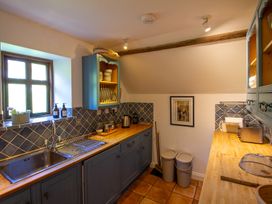 A kitchen with cabinets and sink at Carrows Stable in Morwenstow