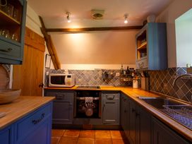 A kitchen with a microwave and oven at Carrows Stable in Morwenstow