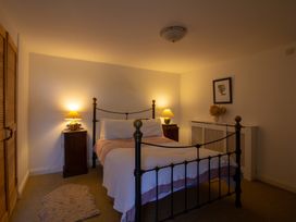 A bedroom with a bed and nightstands at Carrows Stable in Morwenstow
