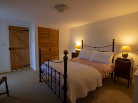 A bedroom with a bed and nightstands at Carrows Stable in Morwenstow