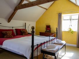 A bedroom with a bed and dresser at Carrows Stable in Morwenstow