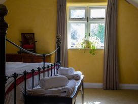 A bedroom with a bed and towels on a bench at Carrows Stable in Morwenstow