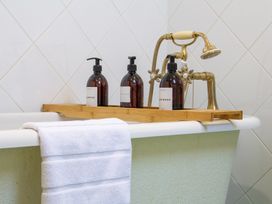 A bathtub with shampoo, conditioner, and bodywash at Carrows Stable Morwenstow