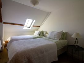 A bedroom with two beds and a window at Carrows Stable Morwenstow