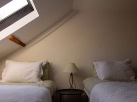 A bedroom with two beds and a lamp at Carrows Stable in Morwenstow