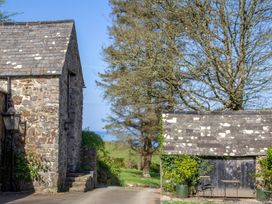 An outdoor view of stone buildings and trees at Carrows Stable Morwenstow