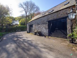 An outdoor photo of a stone building with black doors at Carrows Stable Morwenstow