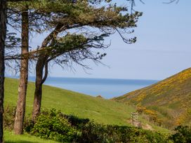 A view of hills and the sea from a grassy area at Carrows Stable in Morwenstow