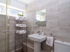 A bathroom with shower, sink, and towel rack at 13 Manorcombe Bungalows near Gunnislake