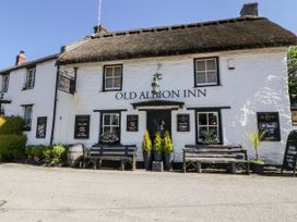 A pub building with signage and benches at Old Albion Inn in Crantock