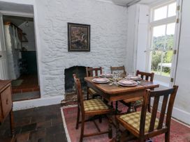 A dining room with a table set for a meal at Dolwylan Cottage in Cwmtydu near New Quay
