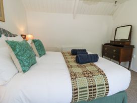 A bedroom with a bed and dresser at Dolwylan Cottage Cwmtydu near New Quay