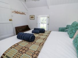 A bedroom with towels on a bed and a door leading to outside at Dolwylan Cottage in Cwmtydu near New Quay