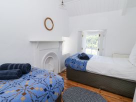 A bedroom with a bed and window at Dolwylan Cottage Cwmtydu near New Quay