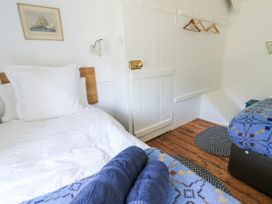 A bedroom with two beds and a door at Dolwylan Cottage Cwmtydu near New Quay
