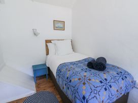 A bedroom with a single bed and a nightstand at Dolwylan Cottage in Cwmtydu near New Quay