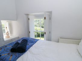A bedroom with a bed and towels at Dolwylan Cottage in Cwmtydu near New Quay