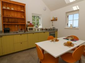 A kitchen with a table and chairs at Dolwylan Barn in Cwmtydu near New Quay