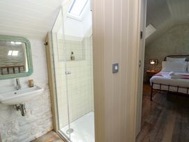 A bedroom with a bed and a shower area at Dolwylan Barn in Cwmtydu near New Quay
