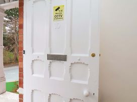A door with a CCTV warning sign and a mail slot at Beachwalk Villa 1