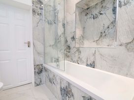 A bathroom with a bathtub and shower at Beachwalk Villa 1