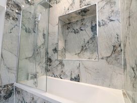 A bathroom with a shower and bathtub at Beachwalk Villa 1