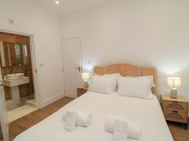 A bedroom with a bed and bathroom access at Beachwalk Villa 1 in Whitby