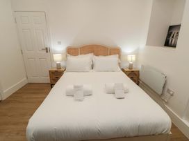A bedroom with a bed and bedside tables at Beachwalk Villa 1, Whitby