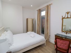 A bedroom with a bed and a mirror at Beachwalk Villa 1 in Whitby