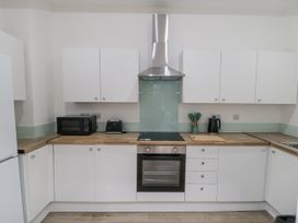 A kitchen with cabinets, a cooker, and appliances at Beachwalk Villa 1 in Whitby