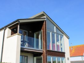 A house with a balcony and large windows at 10 Oceans Edge in Thurlestone