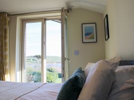A bedroom with a bed and window at 10 Oceans Edge in Thurlestone