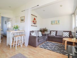 A living room with two gray sofas a rug a coffee table and a small dining table with stools at 224 Atlantic Bays in St Merryn
